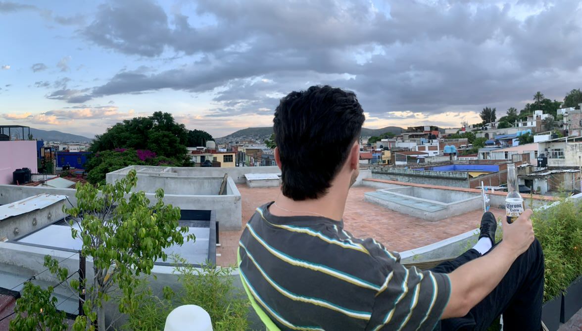 A photo taken from a hostel rooftop with a view of the city and mountains in Oaxaca, Meixco